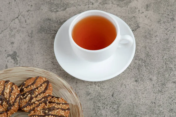 Susamlı kurabiyeler ve mermer yüzeyde bir fincan çay. Yüksek kalite fotoğraf