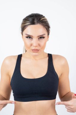 Siyah tarlada dikilmiş poz veren formda genç bir kadın resmi. Yüksek kalite fotoğraf