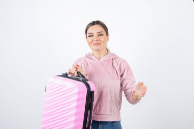 Pembe valizli güzel bir kadının fotoğrafı beyazın üzerinde duruyor. Yüksek kalite fotoğraf