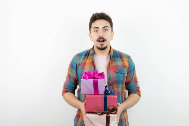 Çekici bir adamın portresi hediye kutularını tutuyor ve kameraya bakıyor. Yüksek kalite fotoğraf