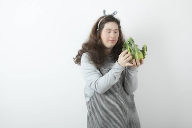 Kıvırcık saçlı, elinde taze, sağlıklı karnabahar tutan güzel bir kızın fotoğrafı. Yüksek kalite fotoğraf