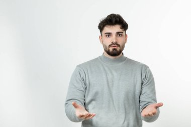 Gri kazaklı yakışıklı adam ayakta ve poz veriyor. Yüksek kalite fotoğraf