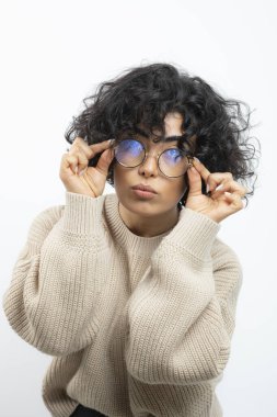 Gözlüklü güzel kıvırcık kadın kameraya bakıyor. Yüksek kalite fotoğraf