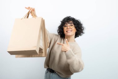 Esmer bir kadının gözlüklü hali. Elinde el işi çantaları var. Yüksek kalite fotoğraf