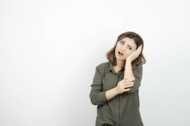 Beyaz duvarda başı ağrıyan genç bir kızın fotoğrafı. Yüksek kalite fotoğraf