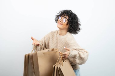 Kendine güvenen bir kadının alışveriş torbaları tutarken çekilmiş bir fotoğrafı. Yüksek kalite fotoğraf