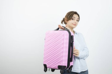 Kadın turist ayakta ve elinde pembe bir valiz tutuyor. Yüksek kalite fotoğraf