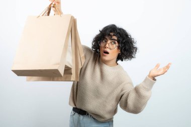 Esmer bir kadının gözlüklü hali. Elinde el işi çantaları var. Yüksek kalite fotoğraf