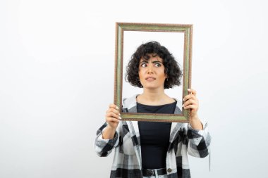 Esmer, güzel bir kadın, elinde eski, ahşap bir çerçeve tutuyor. Yüksek kalite fotoğraf