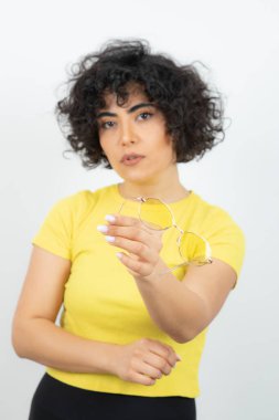 Sarı tişörtlü kadın beyaz arka planda poz veriyor