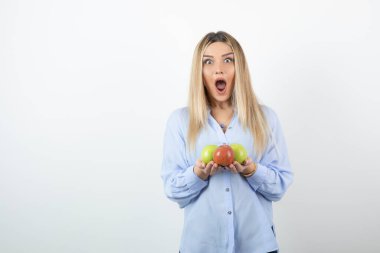 Elinde yeşil ve kırmızı elmalar tutan sarışın bir kızın portresi. Yüksek kalite fotoğraf