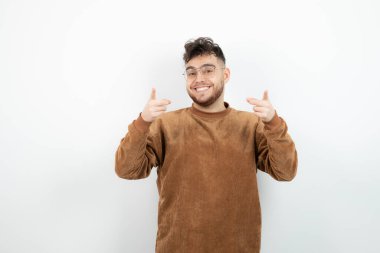 Beyaz duvarın arkasında duran genç erkek modelin görüntüsü. Yüksek kalite fotoğraf