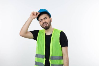 Mavi miğferli genç inşaat işçisinin beyaz kaskın üzerinde durması. Yüksek kalite fotoğraf