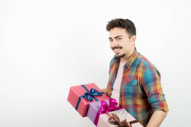 Çekici bir adamın portresi hediye kutularını tutuyor ve kameraya bakıyor. Yüksek kalite fotoğraf