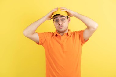 Turuncu üniformalı genç adam ayakta ve poz veriyor. Yüksek kalite fotoğraf