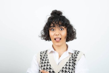 Beyazın üzerinde duran ve poz veren kıvırcık bir kadın resmi. Yüksek kalite fotoğraf