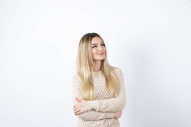 Kollarını beyazın üzerinde birleştirmiş güzel bir kadın görüntüsü. Yüksek kalite fotoğraf