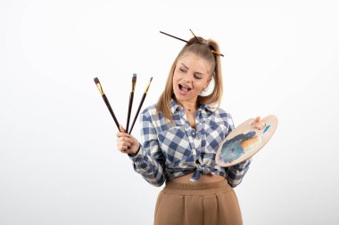 Fırçalı ve renkli paletli kadın ressam resmi. Yüksek kalite fotoğraf