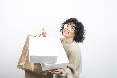 Alışveriş torbalarını beyaz üzerinde taşıyan mutlu bir kadın. Yüksek kalite fotoğraf