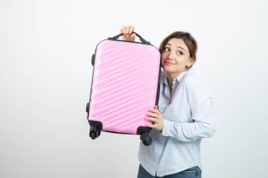 Kadın turist ayakta ve elinde pembe bir valiz tutuyor. Yüksek kalite fotoğraf