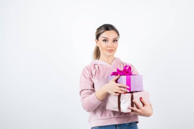 Hediye kutularıyla poz veren ve ayakta duran çekici genç bir manken. Yüksek kalite fotoğraf