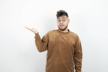 Beyaz duvarın arkasında duran genç erkek modelin görüntüsü. Yüksek kalite fotoğraf