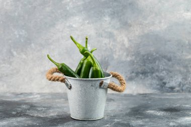 Kovadaki yeşil biberler mermer arka planda. Yüksek kalite fotoğraf