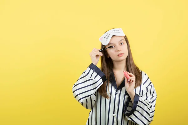 Una Hermosa Joven Pijama Que Aplica Rímel Contra Pared Amarilla — Foto de Stock