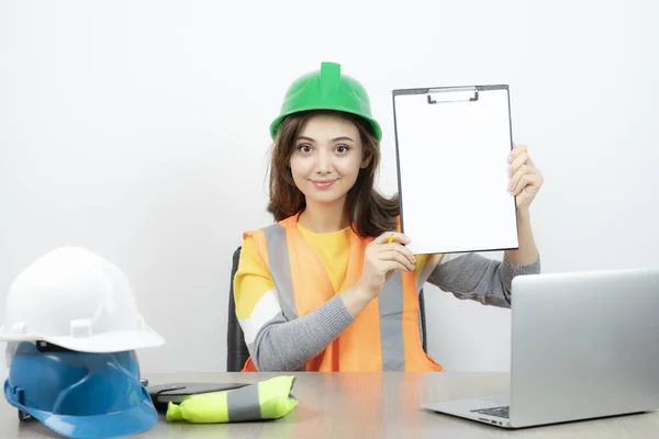 Arbeiterinnen Uniform Sitzen Schreibtisch Mit Laptop Und Klemmbrett Hochwertiges Foto — Stockfoto