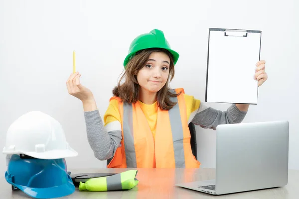 Arbeiterinnen Uniform Sitzen Schreibtisch Mit Laptop Und Klemmbrett Hochwertiges Foto — Stockfoto