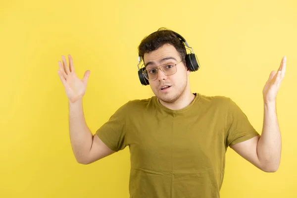 Een Knappe Jongeman Met Een Koptelefoon Die Een Gele Muur — Stockfoto