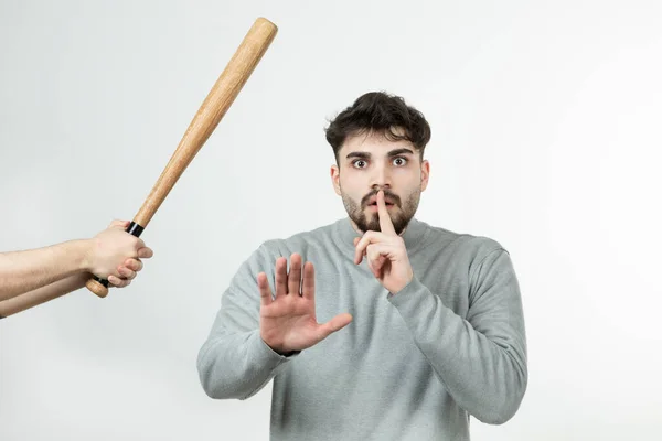 白い壁の上に野球バットの近くに立ってハンサムな男の写真 高品質の写真 — ストック写真