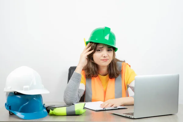 Arbeiterinnen Uniform Sitzen Schreibtisch Mit Laptop Und Klemmbrett Hochwertiges Foto — Stockfoto