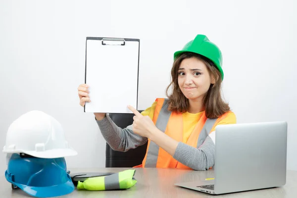 Arbeiterinnen Uniform Sitzen Schreibtisch Mit Laptop Und Klemmbrett Hochwertiges Foto — Stockfoto