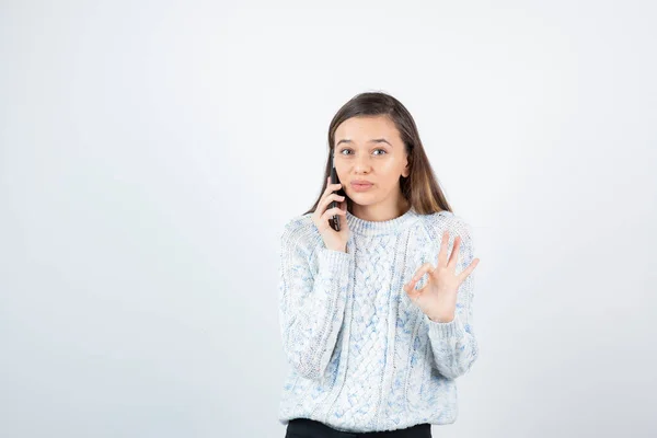 Menina Vestindo Suéter Posando Com Smartphone Fundo Branco — Fotografia de Stock