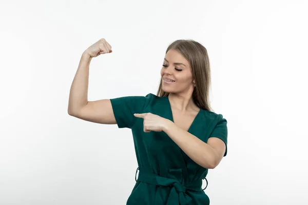 Foto Una Mujer Rubia Pie Señalando Sus Bíceps Foto Alta — Foto de Stock