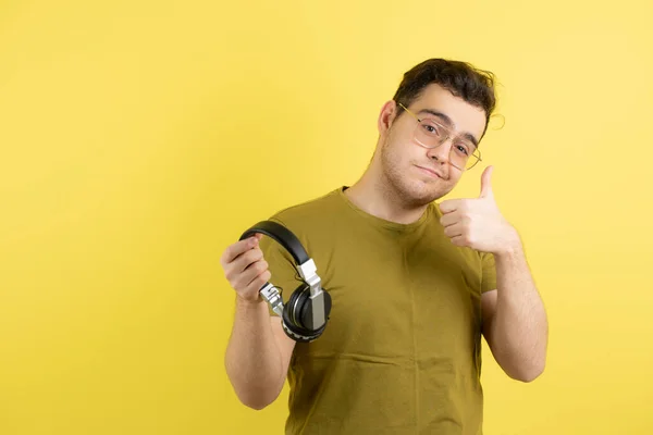 Imagen Hombre Guapo Con Gafas Sosteniendo Auriculares Dando Pulgares Hacia —  Fotos de Stock