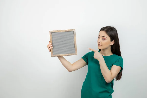 Junge Schöne Frau Steht Und Zeigt Auf Rahmen Vor Isoliertem — Stockfoto