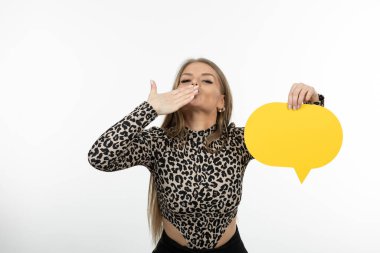 Hava öpücüğü veren ve sarı konuşma balonu tutan hoş görünümlü bir kadın. Yüksek kalite fotoğraf