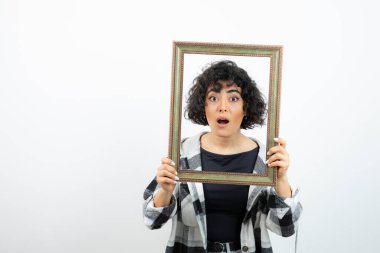 Esmer, güzel bir kadın, elinde eski, ahşap bir çerçeve tutuyor. Yüksek kalite fotoğraf