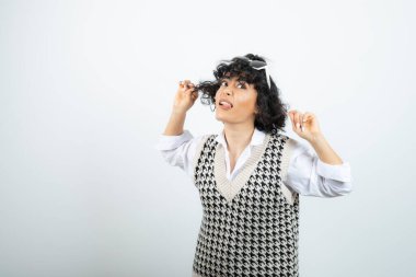 Güneş gözlüklü, ayakta duran ve poz veren alımlı genç bir kadın. Yüksek kalite fotoğraf