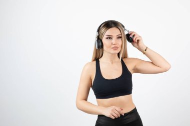 Kulaklıklı, spor elbiseli güzel bir kadın. 