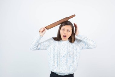 Beyaz arka planda paten iğnesi olan süveter giyen kız