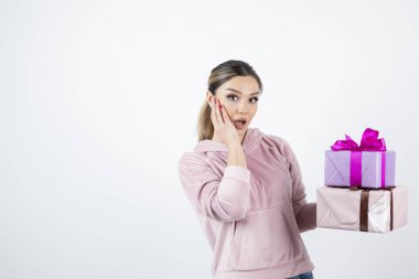 Hediye kutularıyla poz veren ve ayakta duran çekici genç bir manken. Yüksek kalite fotoğraf