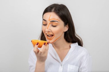 Bir fincan çay ve sağlıklı bir kahvaltıyla genç bir kadın.