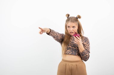 Üstünde kırmızı soğan tutan, kırpık bluzlu genç bir kadın resmi. Yüksek kalite fotoğraf