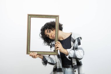 Esmer, güzel bir kadın, elinde eski, ahşap bir çerçeve tutuyor. Yüksek kalite fotoğraf