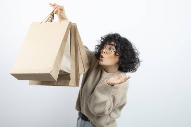Esmer bir kadının gözlüklü hali. Elinde el işi çantaları var. Yüksek kalite fotoğraf