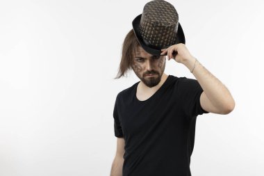 Yüzü boyalı, ayakta duran ve şapka takan sakallı adamın fotoğrafı. Yüksek kalite fotoğraf