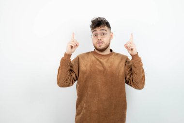 Beyaz duvarın arkasında duran genç erkek modelin görüntüsü. Yüksek kalite fotoğraf